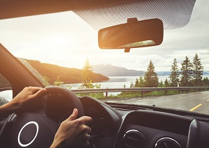 person driving a car overlooking a lake